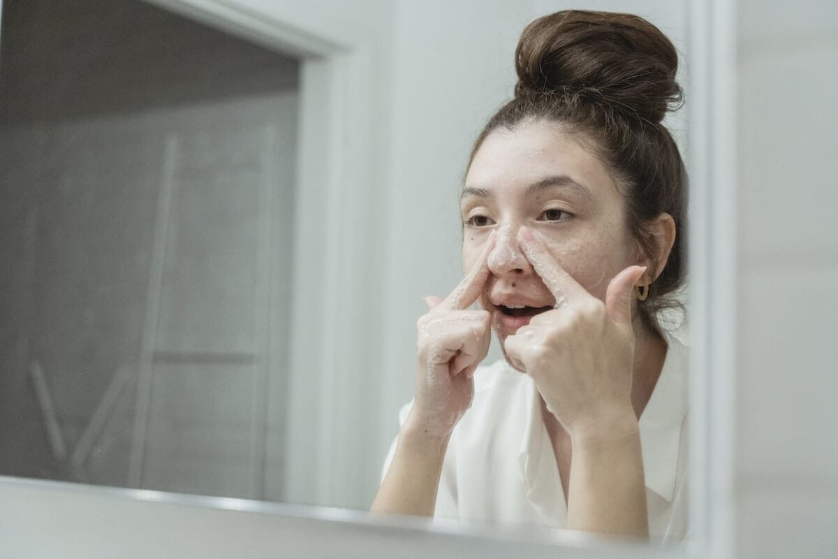 Young Woman Washing Her Face in the Bathroom To Reduce Acne