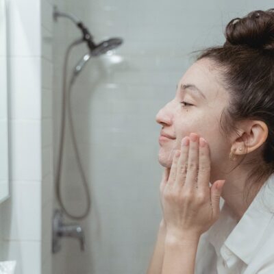 A young woman washes her face with a soap-free cleanser