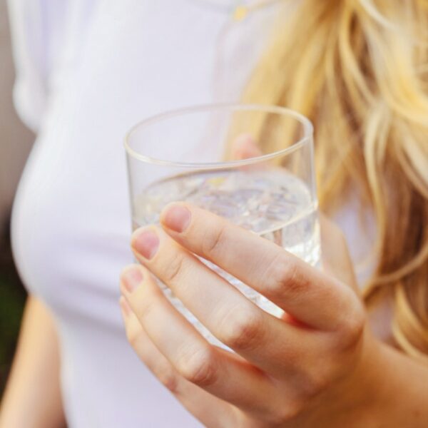 a woman holding a glass of water in her hand